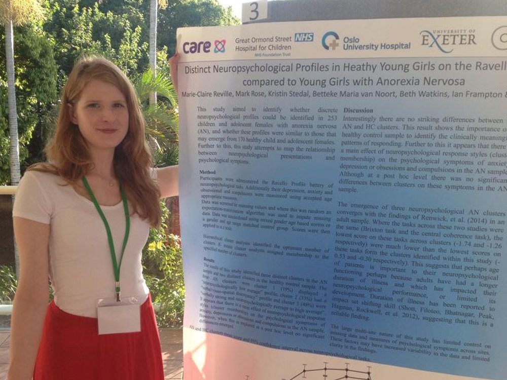 Dr Marie-Claire Reville beside a research poster at a conference