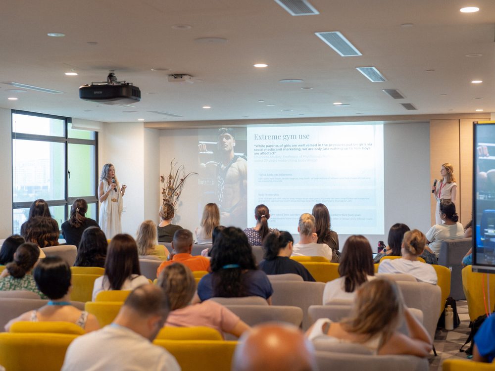 Dr Marie-Claire Reville presenting to a seated room of attendees